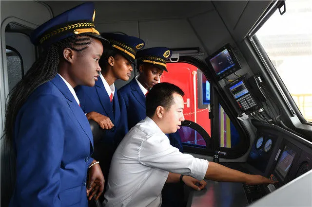在肯尼亚内罗毕，肯尼亚火车司机跟随中国老师张程熟悉操作流程（2017年5月17日摄）。新华社记者 孙瑞博 摄
