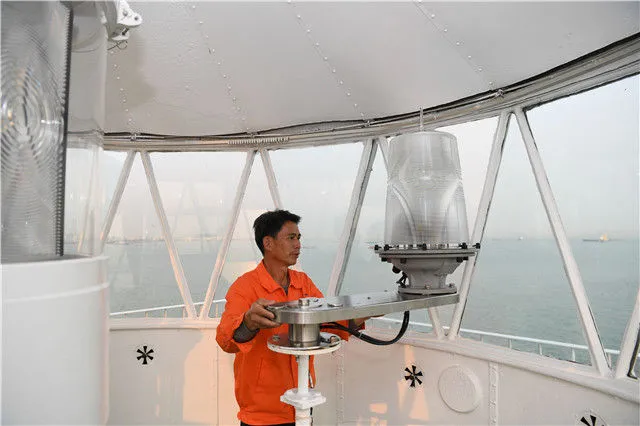在珠江口伶仃洋北端的舢舨洲，航标工黄灿明在检查灯塔辅灯设备（2019年4月2日摄）。新华社记者 邓华 摄