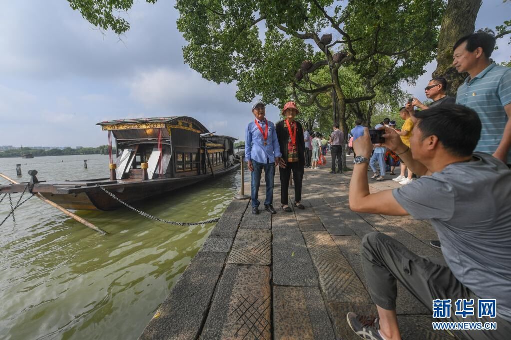 7月1日，两名老党员在浙江嘉兴南湖湖心岛停泊的南湖红船旁拍照留影。新华社记者 徐昱 摄