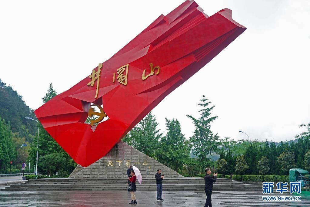 游客在江西井冈山“井冈红旗”雕塑前参观、拍照（4月27日摄）。新华社记者 万象 摄